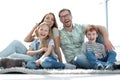 Cheerful family sitting on the carpet in the new living room Royalty Free Stock Photo