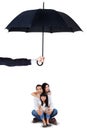 Cheerful family sitting under umbrella in studio Royalty Free Stock Photo