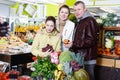 Cheerful family with small daughter standing near full grocery cart Royalty Free Stock Photo