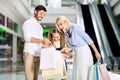 Cheerful Family Of Three Looking Into Bags Standing In Hypermarket