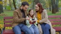 Cheerful family together happy man father woman mother child kid girl little daughter outdoors park on bench dad mom Royalty Free Stock Photo