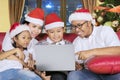 Cheerful family using a laptop at Christmas time Royalty Free Stock Photo