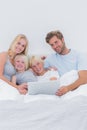 Cheerful family using a laptop in bed Royalty Free Stock Photo