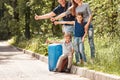 Cheerful family votes standing on the side of the road