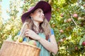 Cheerful farmer harvesting juicy nutritious organic fruit in season to eat. A happy woman from below holding basket of Royalty Free Stock Photo