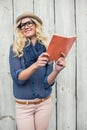 Cheerful fashionable blonde holding book outdoors Royalty Free Stock Photo