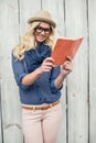 Cheerful fashionable blonde reading outdoors Royalty Free Stock Photo