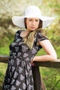 Cheerful fashionable woman in stylish hat and frock posing