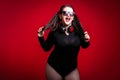 Cheerful fat brunette has fun posing with headphones. Plus size model, wear bodysuit in the studio with big boobs Royalty Free Stock Photo