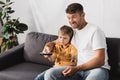 Cheerful father and bored son clicking Royalty Free Stock Photo