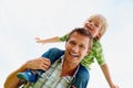 Cheerful father carrying his son on shoulder against white. Portrait of a smiling father carrying his son on shoulder Royalty Free Stock Photo