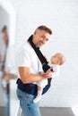 cheerful father holding infant daughter in baby carrier Royalty Free Stock Photo