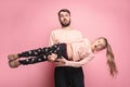 Cheerful father playing with daughter on pink Royalty Free Stock Photo