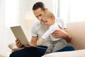 Kind positive father sitting with his child and looking at the gadget