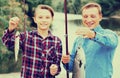 Cheerful father with son looking at fish on hook Royalty Free Stock Photo