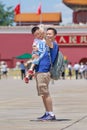 Cheerful father and son takes selfie on sunny Tiananmen Square, Beijing, China