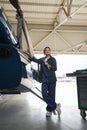 Charming Caucasian woman in uniform working in hangar Royalty Free Stock Photo