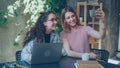 Cheerful female colleagues are making selfie with smart phone while relaxing in workplace. Office fun concept. Royalty Free Stock Photo