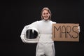 Cheerful female cosmonaut is standing with cardboard Royalty Free Stock Photo