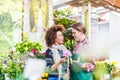 Cheerful female customer buying flowers at the advice of a helpful vendor Royalty Free Stock Photo