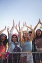 Cheerful female fans against clear sky enjoying music festival Royalty Free Stock Photo