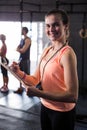 Cheerful female fitness instructor holding clipboard in gym Royalty Free Stock Photo
