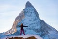 Cheerful female hiker posing against rocky Matterhorn peak in winter