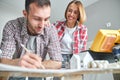 Cheerful female looking at a draftsman at work