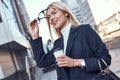 Cheerful female manager getting to work by foot drinking morning