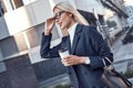 Cheerful female manager getting to work by foot drinking morning