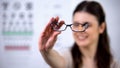 Cheerful female optometrist patient showing new eyeglasses, sight correction Royalty Free Stock Photo