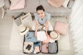 Cheerful Female Packing Suitcase And Getting Ready For Traveling Royalty Free Stock Photo