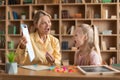 Cheerful female speech therapist curing child's problems and impediments, little girl learning letters during lesson