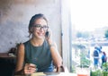 Cheerful female student having cellphone conversation while resting in cafe Royalty Free Stock Photo