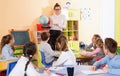 Female teacher giving geography lesson in classroom, showing pupils globe Royalty Free Stock Photo