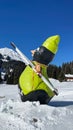 a fake snowman is sitting in the snow with skis