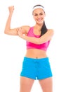 Cheerful fitness young girl showing her muscles