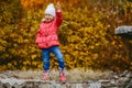 Cheerful five-year girl in pink warm jacket and jeans in full growth autumn. girl posing