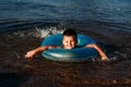 Cheerful five-year-old boy learns to swim in the sea