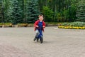 Cheerful five-year-old boy rides a running bike