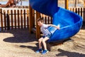 Cheerful five-year-old child rolls down a plastic slide on the Playground
