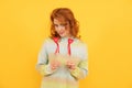 cheerful flirty redhead girl with red heart sticks on yellow background. love