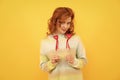 cheerful flirty redhead girl with red heart sticks on yellow background. love