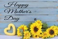 Cheerful floral with bright yellow silk sunflowers and a rustic blue washed plank background for Mother`s Day.