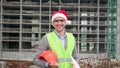 Cheerful foreman posing for camera against unfinished multi-story house Royalty Free Stock Photo