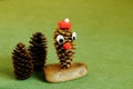 Cheerful forest character made of cones on wooden stand with fir cones on green background. Crafts from cones. Handmade. Concept