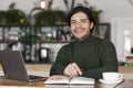 Cheerful freelancer working at cafe, using laptop