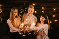 Cheerful friends are clinking glasses Champagne and holds Bengali lights Royalty Free Stock Photo