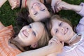 Cheerful friends girls laying in grass together