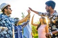 cheerful friends giving high five to each other outdoors in summer park Royalty Free Stock Photo